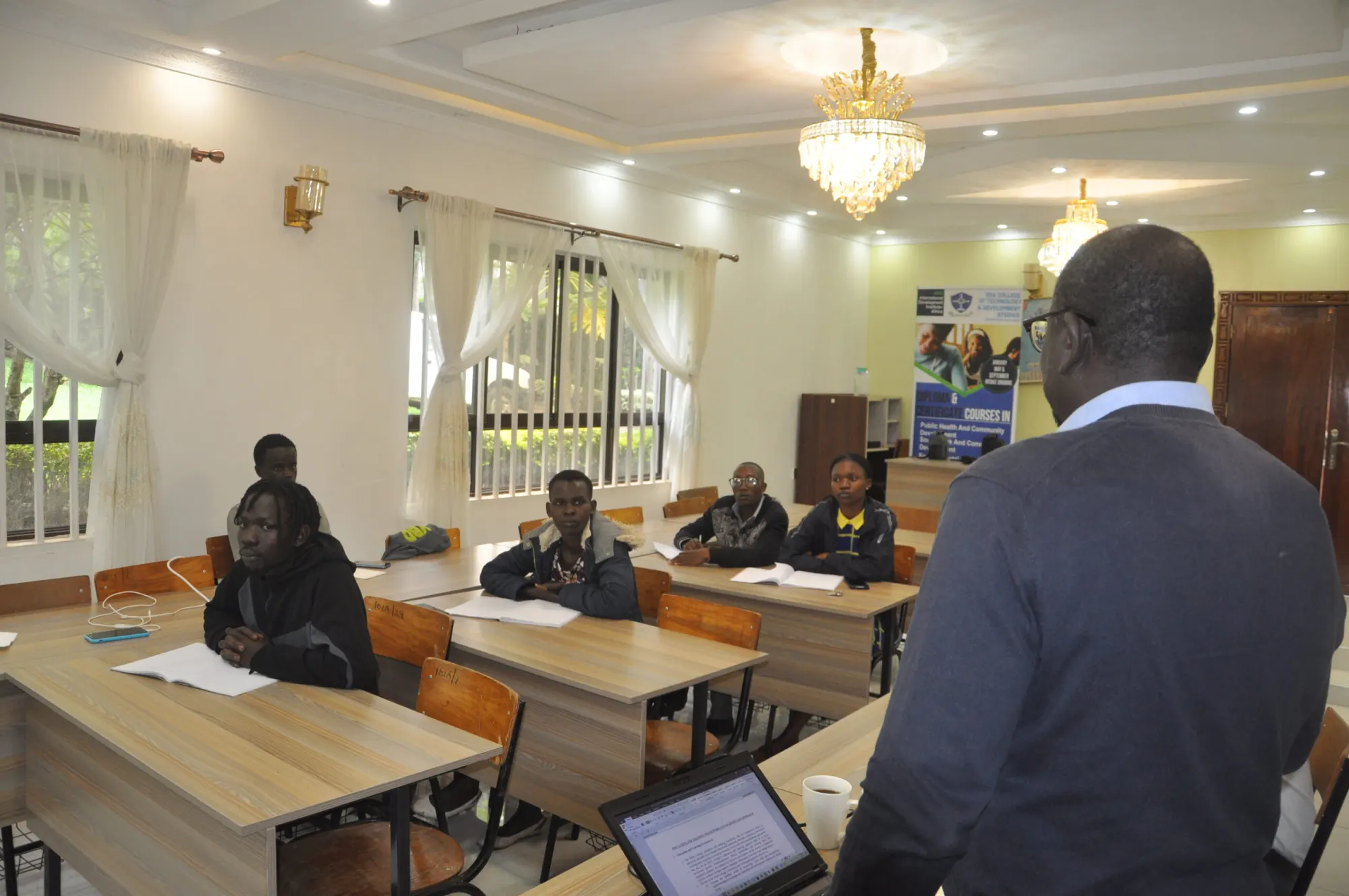 A lecturer teaching a class in a bright IDIA College lecture room